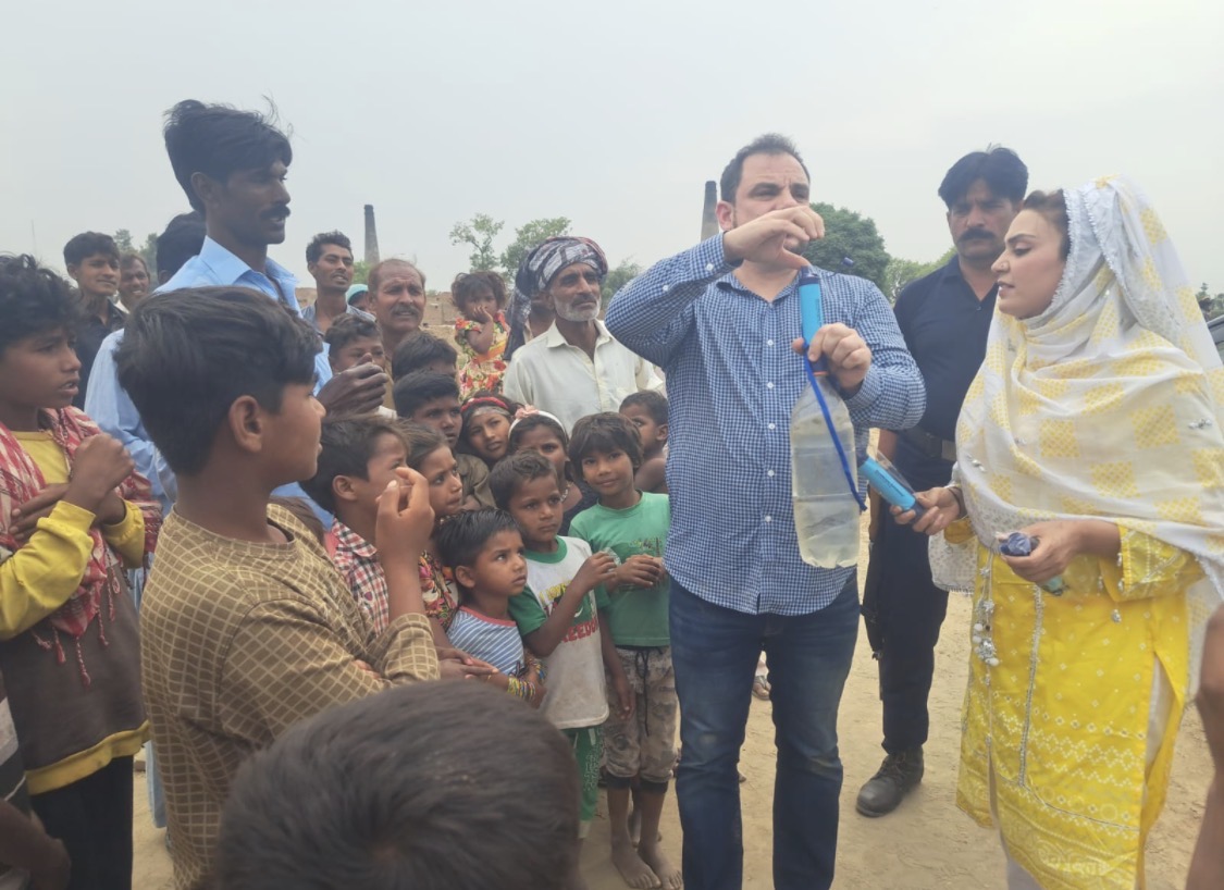 Christopher demonstrates a portable water filter to a group during a GFM visit in Pakistan